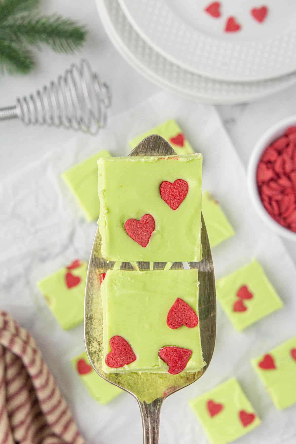 Two pieces of grinch fudge on a serving spatula.