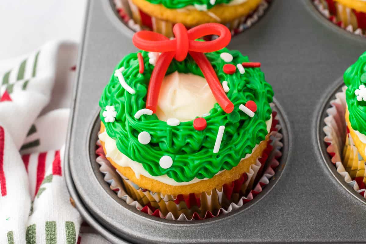 Vanilla cupcake decorated to look like a Christmas wreath.
