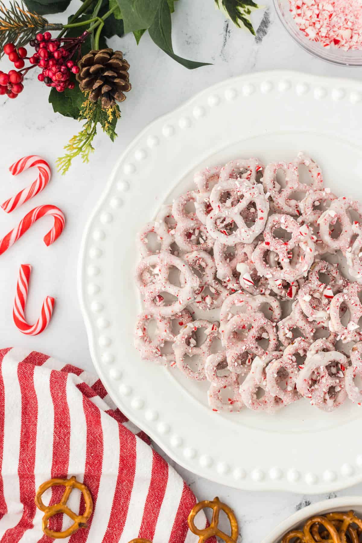 Platter filled with white chocolate pretzels sprinkled with crushed candy canes.