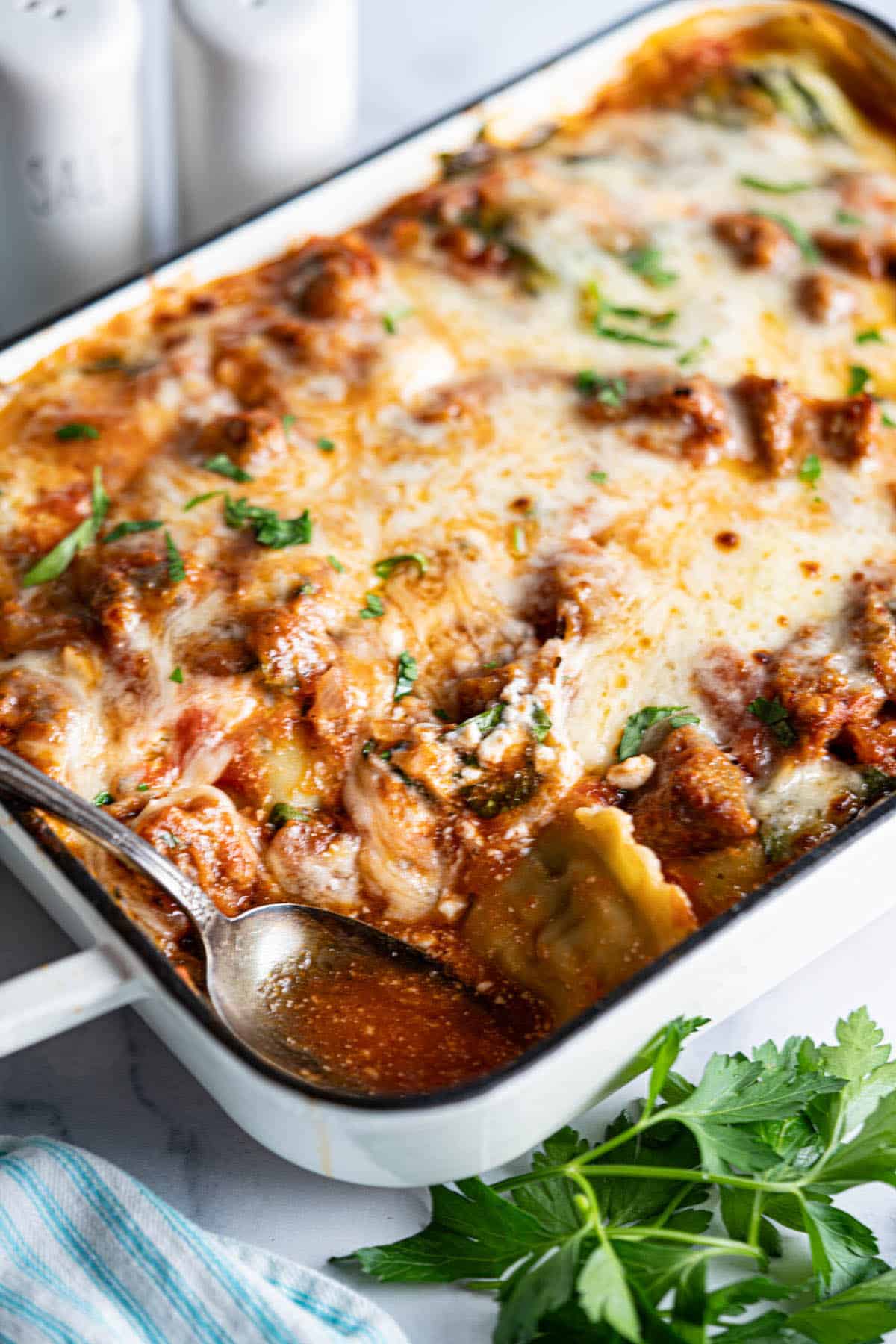 Ravioli Casserole in a baking dish, with a serving spoon.