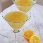Lemon drop martini with sliced lemons on the side.