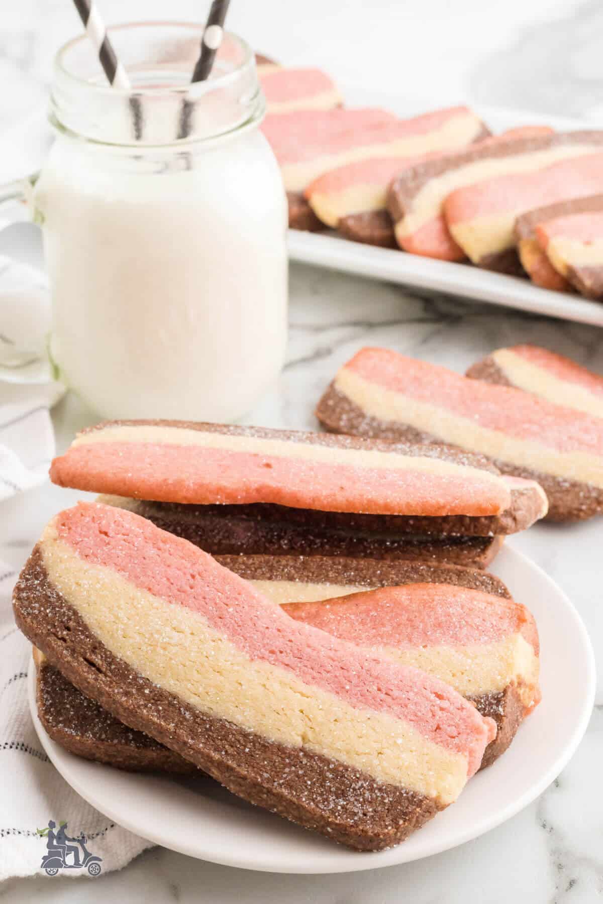 A platter filled with Neopolitan Cookies, served with a glass of milk.