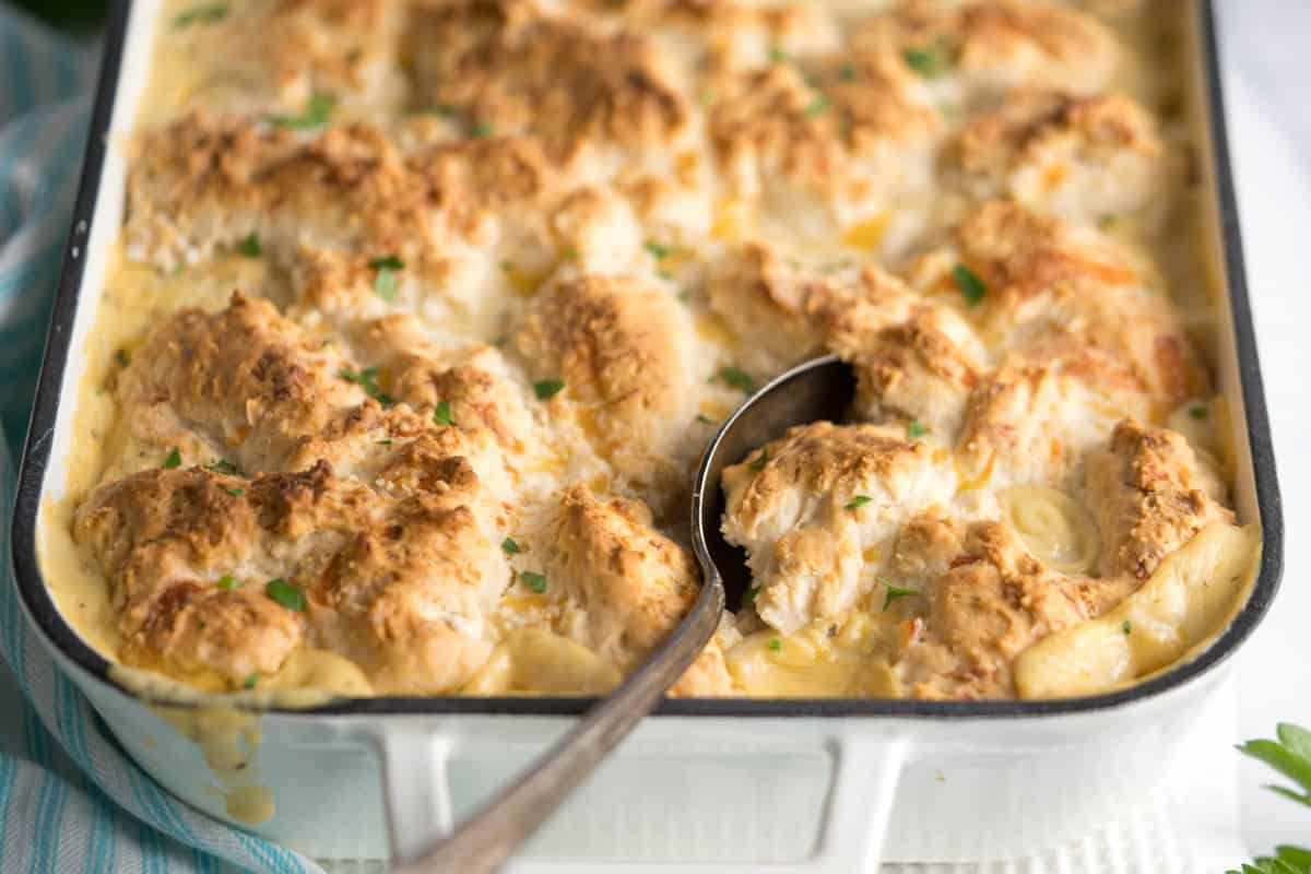 Chicken Cobbler in a baking dish with a serving spoon.