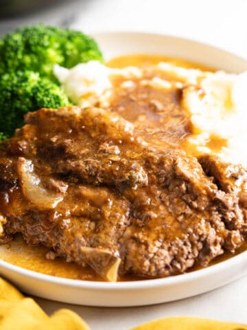Steak smothered in gravy wish mashed potatoes.