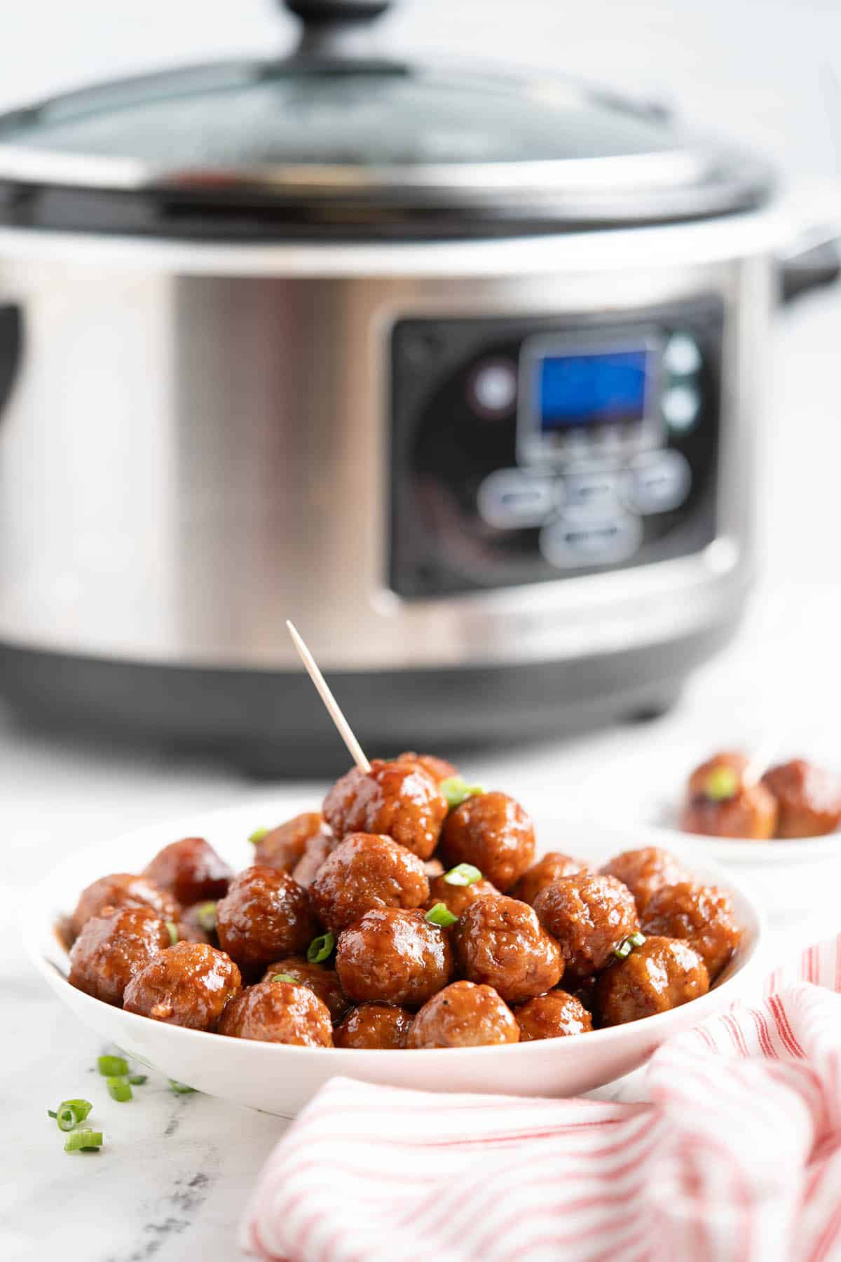 A platter filled with Hidden Valley Grape Jelly Barbecue Meatballs in front of a slow cooker.