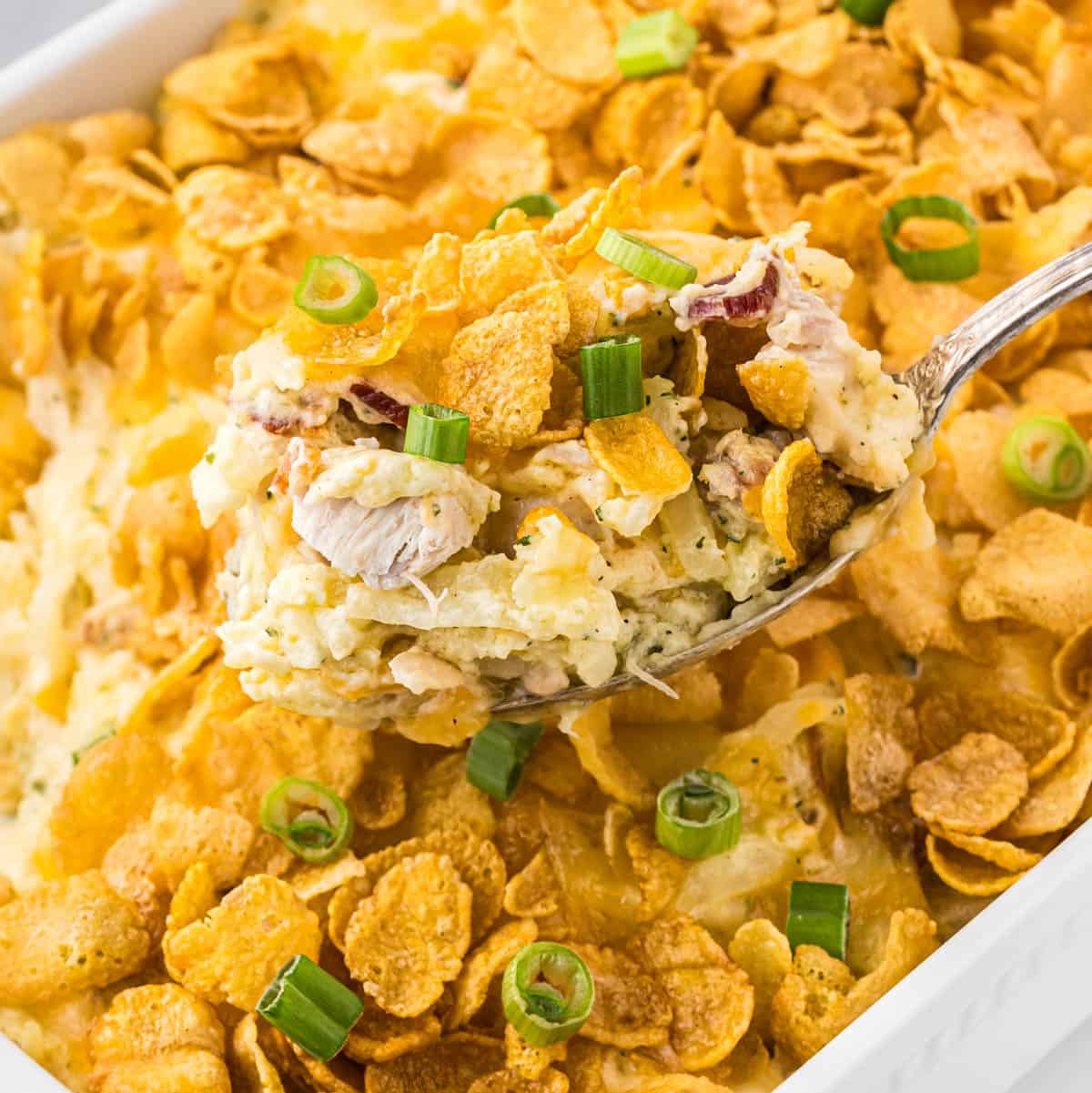 Hashbrown Chicken Casserole in a baking dish with a serving spoon taking a big scoop.