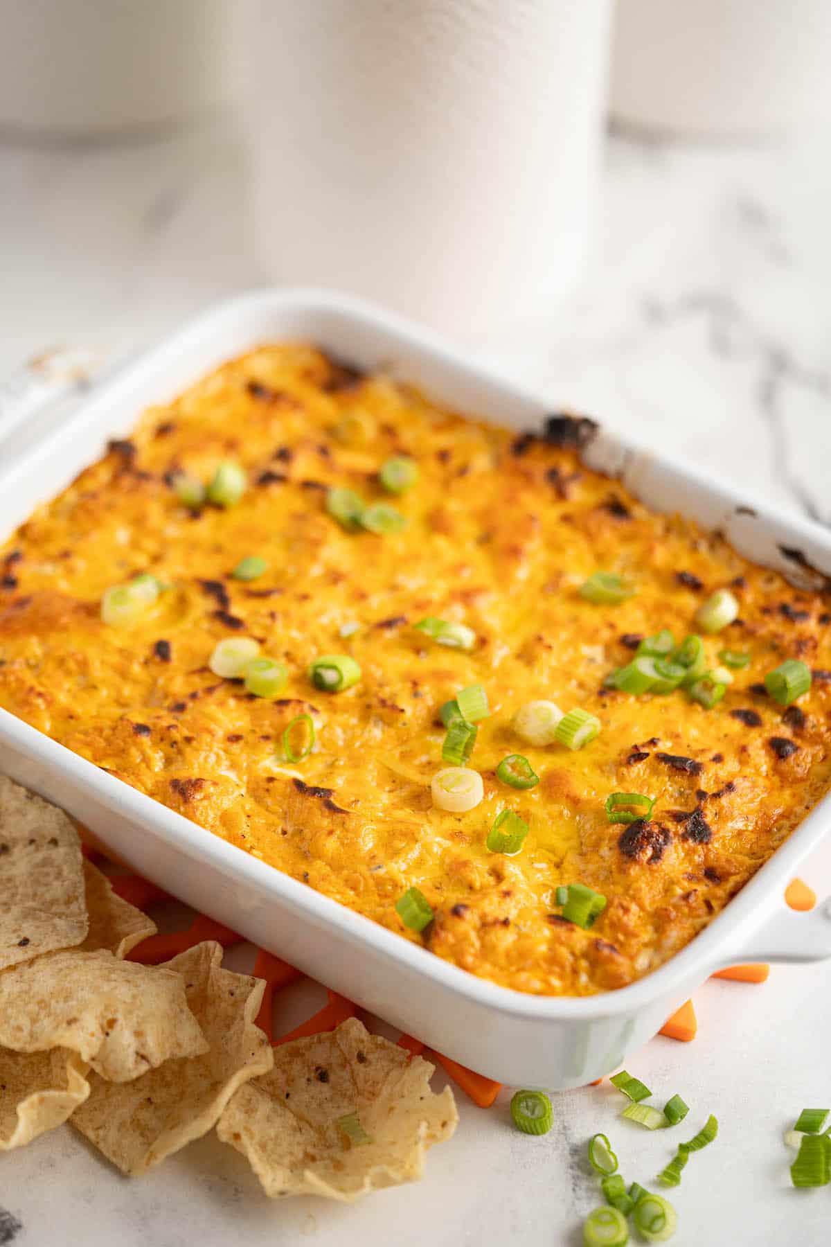 A small casserole dish filled with Hidden Valley Buffalo Chicken Dip. With chips on the side.