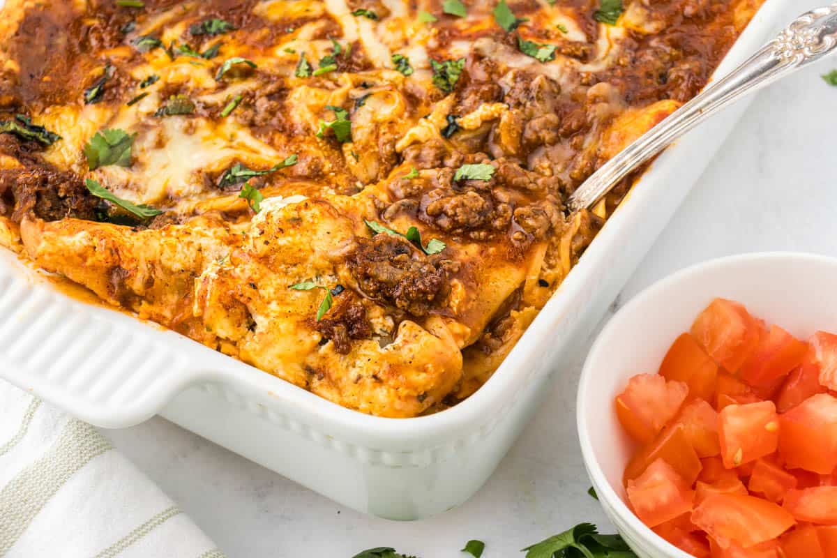 Mexican Lasagna Casserole in a baking dish with a serving spoon.