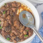 A bowl filled with slow cooker steak bites and gravy.
