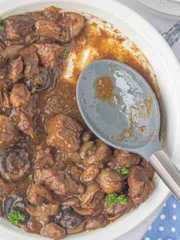 A bowl filled with slow cooker steak bites and gravy.