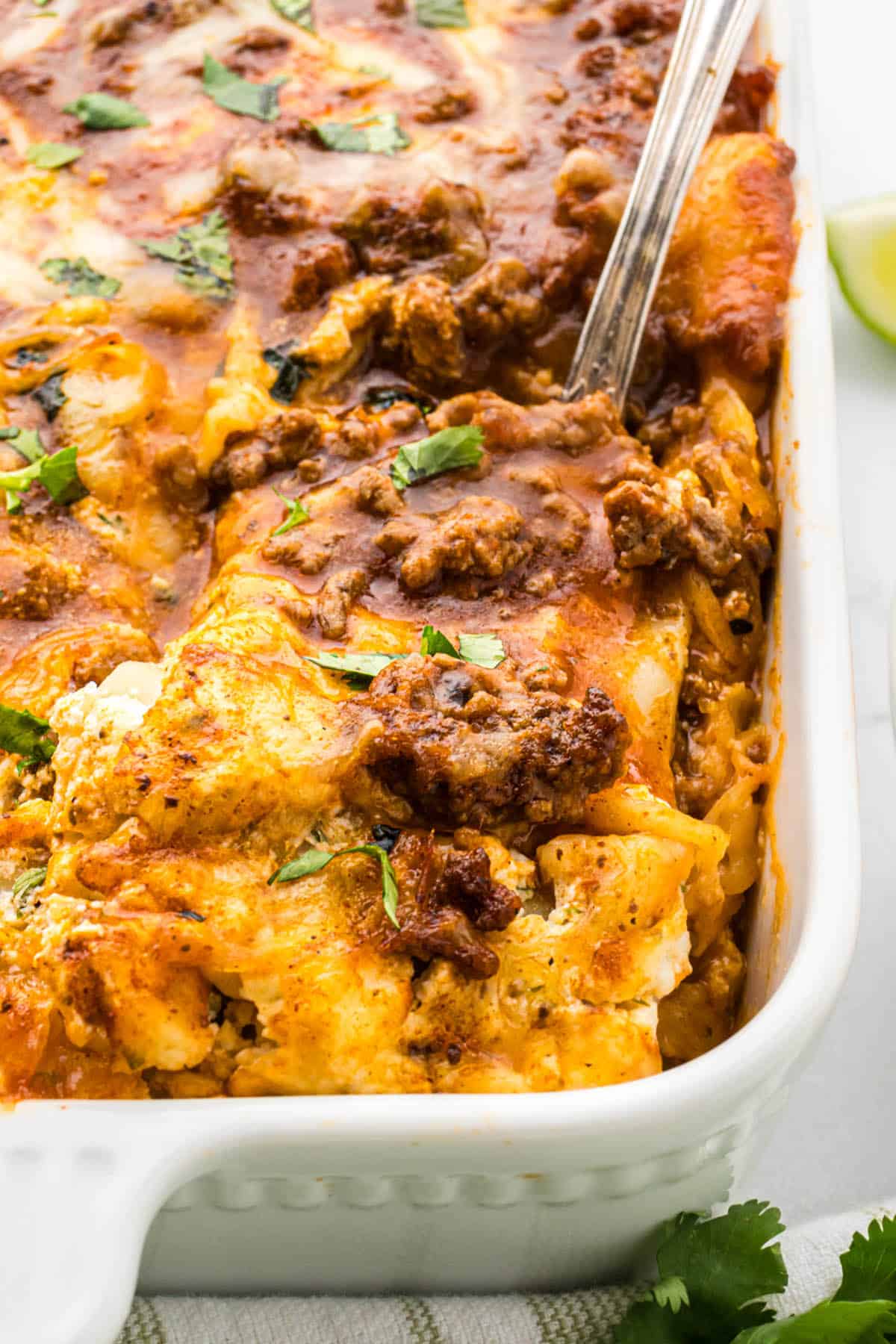 Taco Lasagna Casserole in a baking dish with a serving spoon.