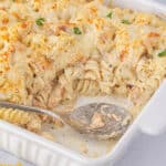 Dump and bake Garlic Parmesan Chicken Pasta in casserole dish, with a serving spoon.