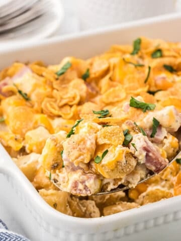 Eggless breakfast casserole in baking dish with a serving spoon taking a big scoop.