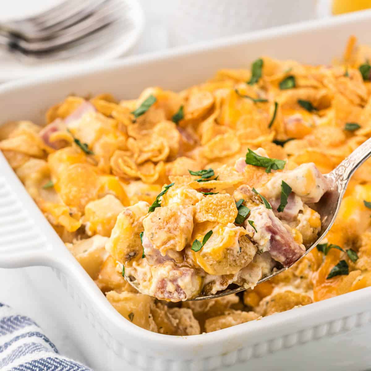 Eggless breakfast casserole in baking dish with a serving spoon taking a big scoop.
