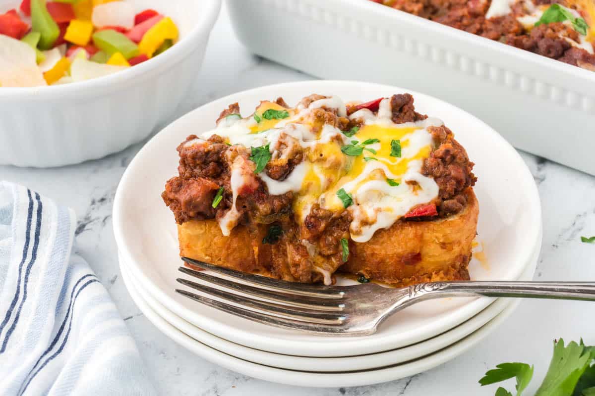 A plate filled with Sloppy Joe Garlic Bread Casserole, with a fork to the side.