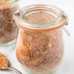 Jars of rub for ribs with a spoon for sprinkling the seasoning.