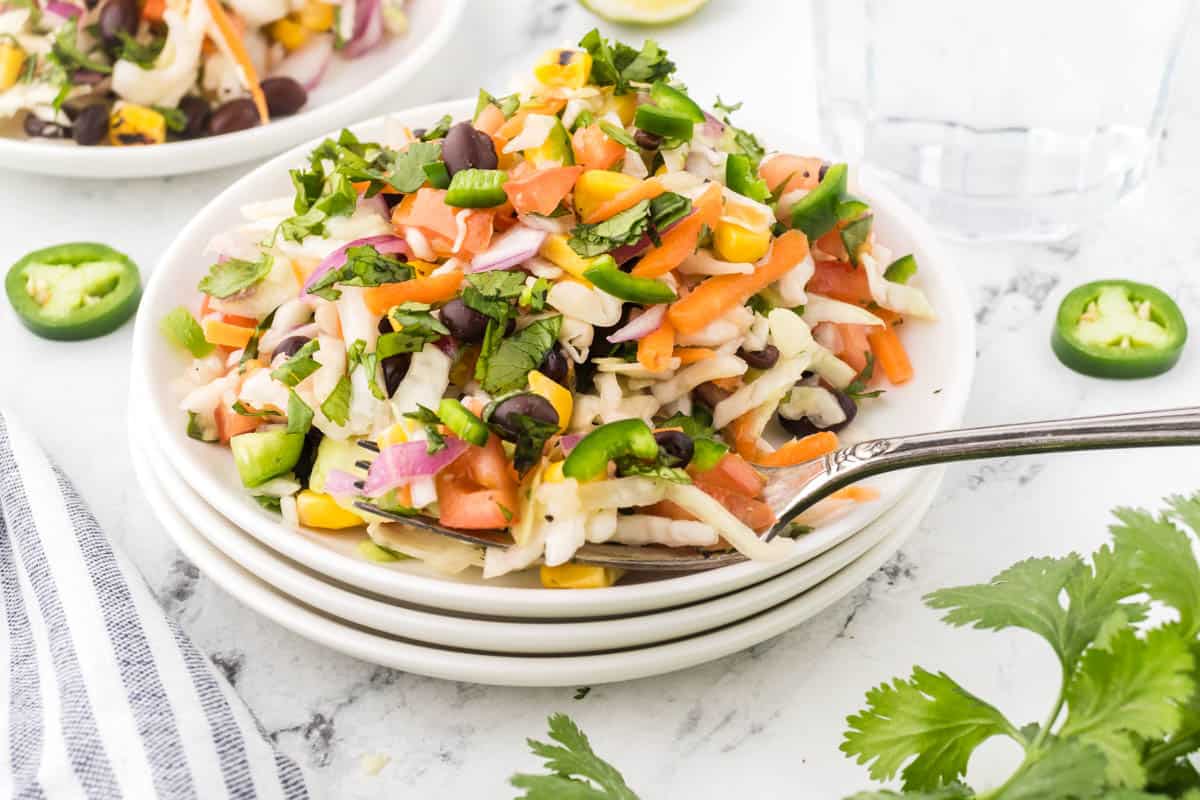 Crunchy Mexican coleslaw piled on a plate with a fork.
