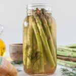 A quarter jar filled with spicy pickled asparagus.