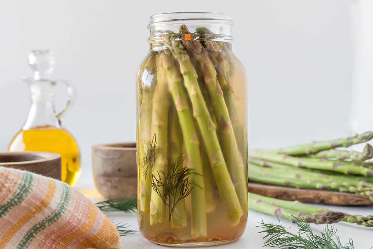 A quarter jar filled with pickled asparagus.