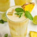 Pineapple Cocktail garnished with mint and a pineapple wedge.
