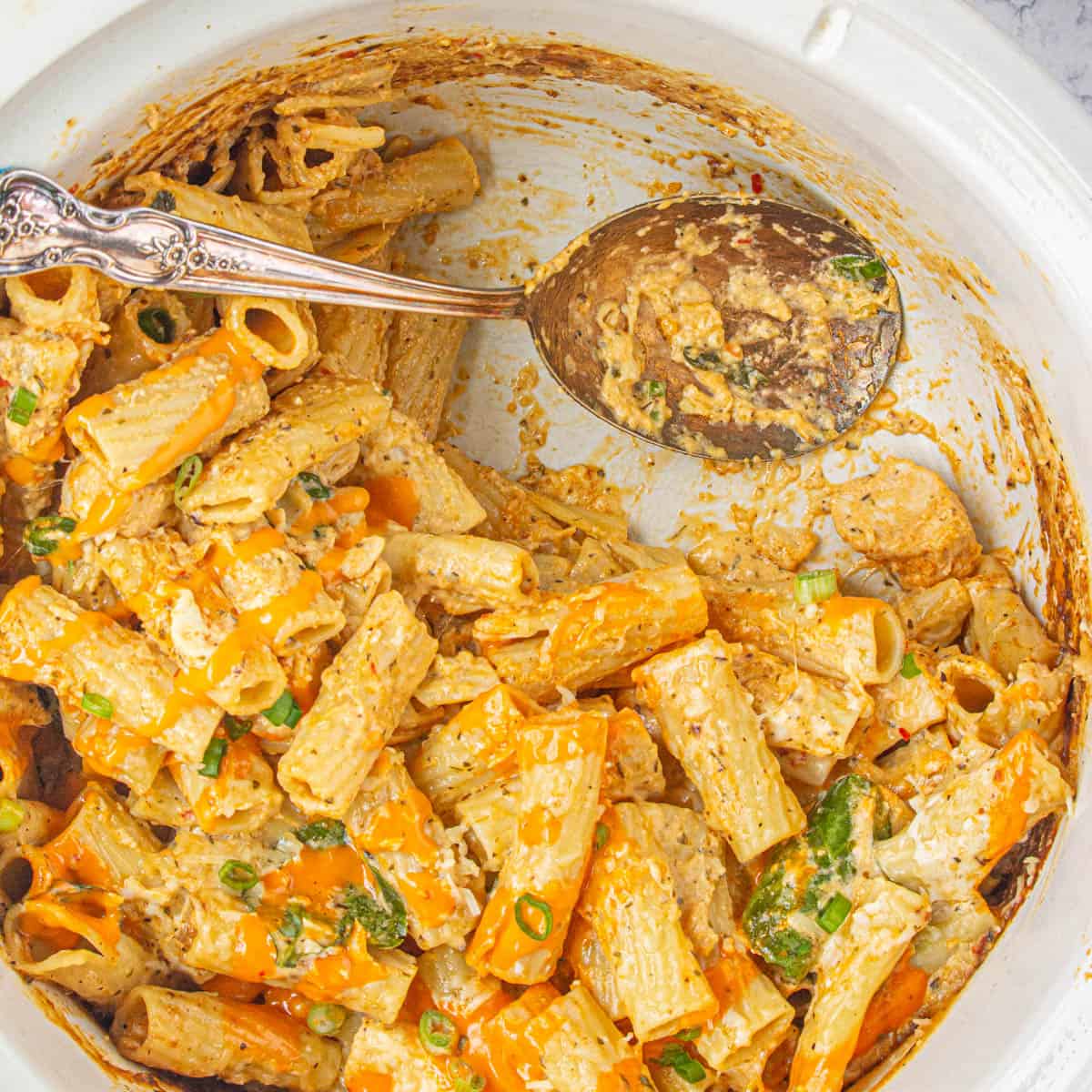 Crockpot Buffalo Chicken in the slow cooker with a serving spoon.