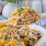 A big bowl of BBQ Chicken Pasta Salad, with a serving spoon grabbing a big scoop.