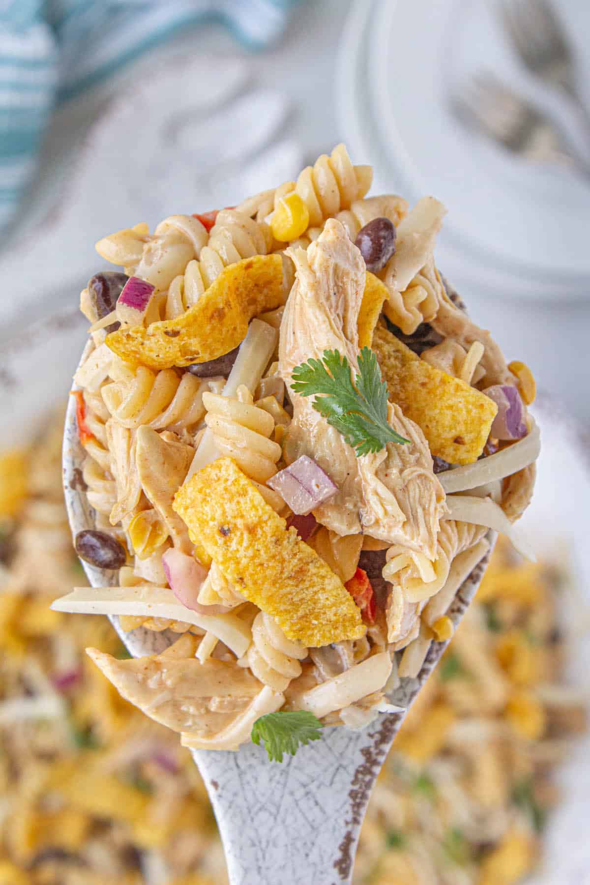 A spoon holding a big scoop of BBQ Chicken Pasta Salad.