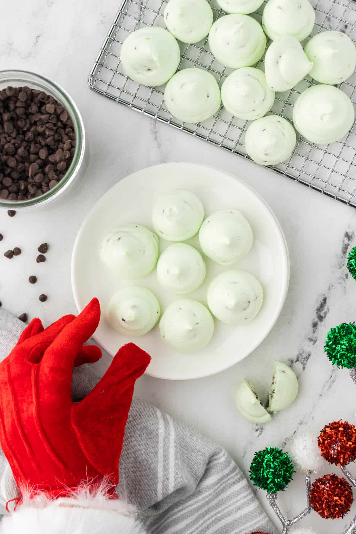 It looks like Santa is stealing a Chocolate Mint Meringue Cookie from a cookie platter.