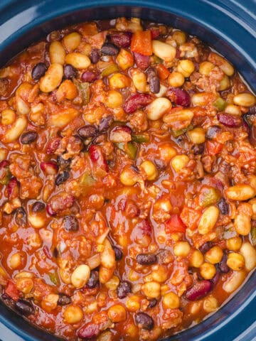 Baked beans in a rich tomato sauce in a crockpot.