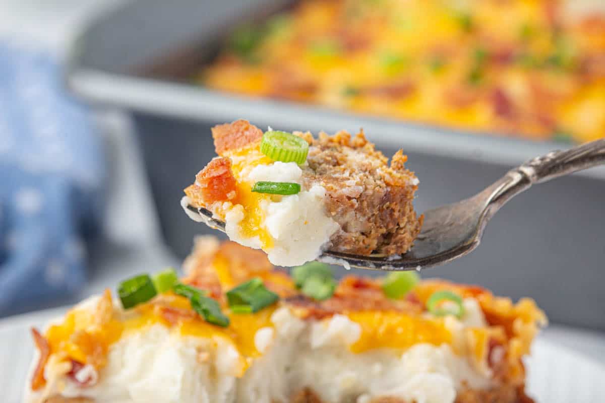 A fork grabbing a bite of potato meatloaf casserole.