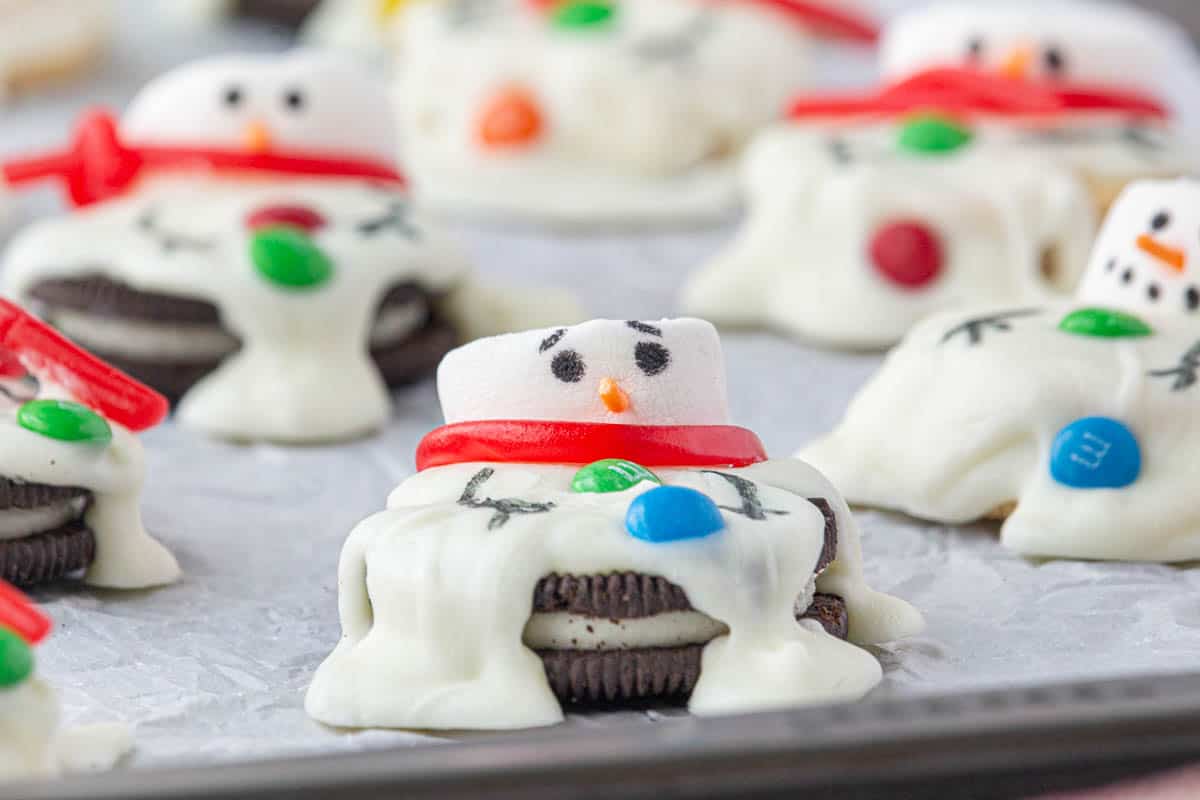 A cookie sheet filled with melted snowman cookies.