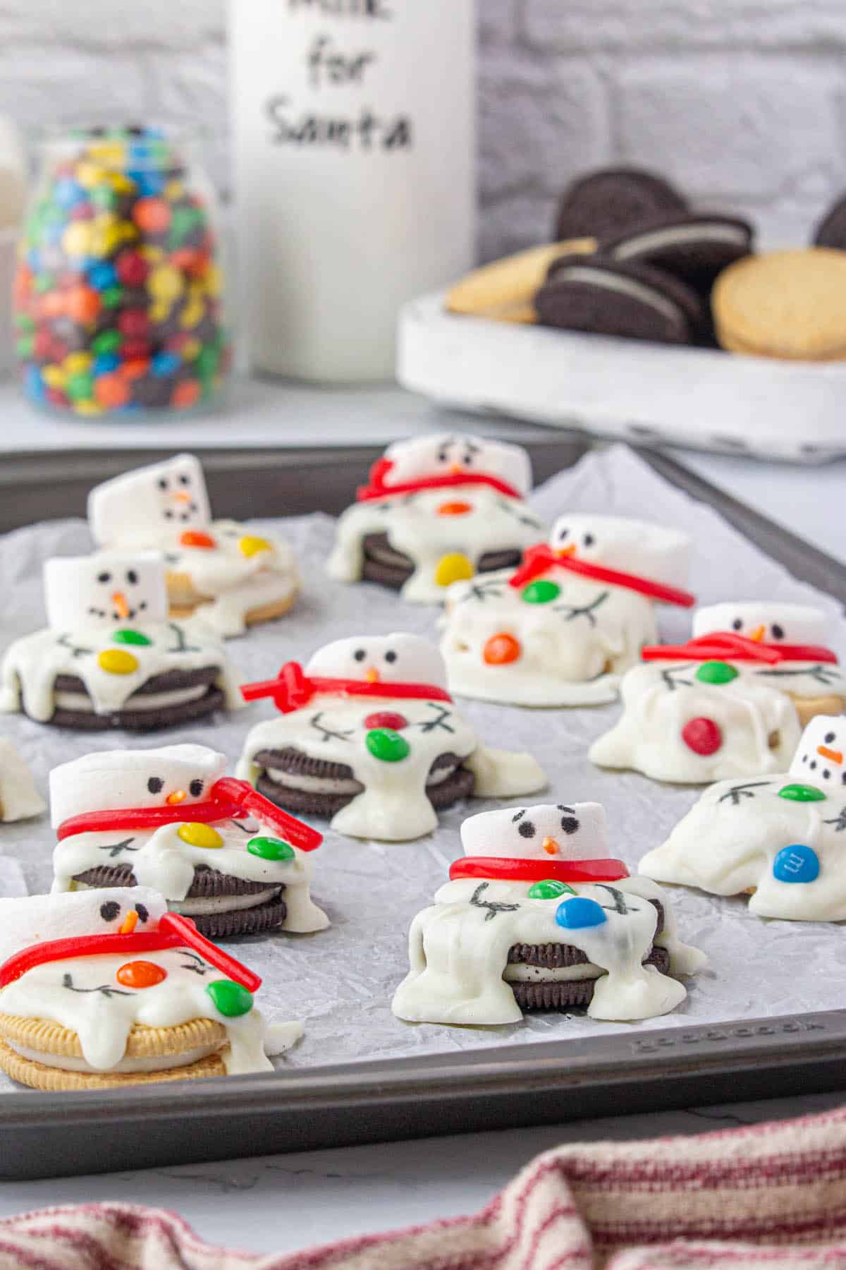 Fun melted snowmen cookies on a baking sheet.