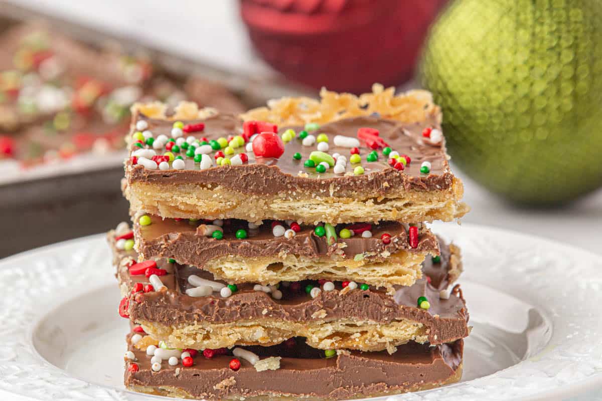 A stack of Saltine Toffee Candy cut into squares, stacked on a plate.