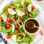 Balsamic Sweet Dressing in a small bowl being drizzled over a salad.