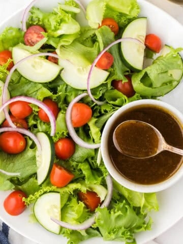 Balsamic Sweet Dressing in a small bowl being drizzled over a salad.