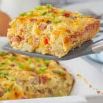 Ham and Hashbrown breakfast casserole in a baking dish with a slice on a spatula.