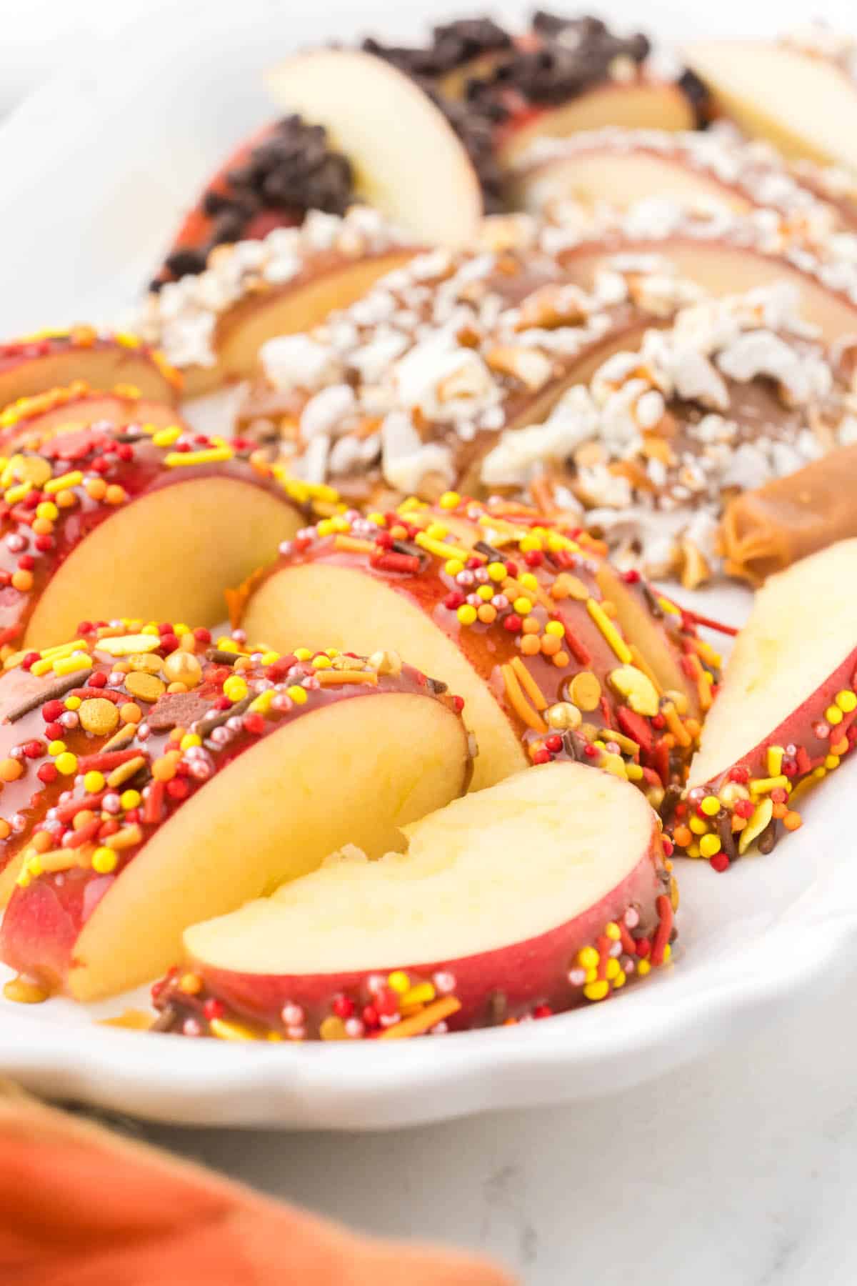 Sliced gourmet caramel apples on a platter.