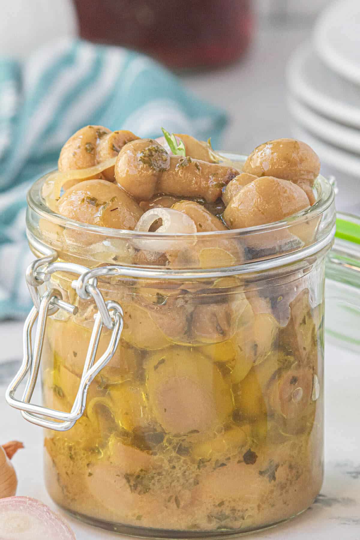 Pickled mushrooms piled high in a jar.