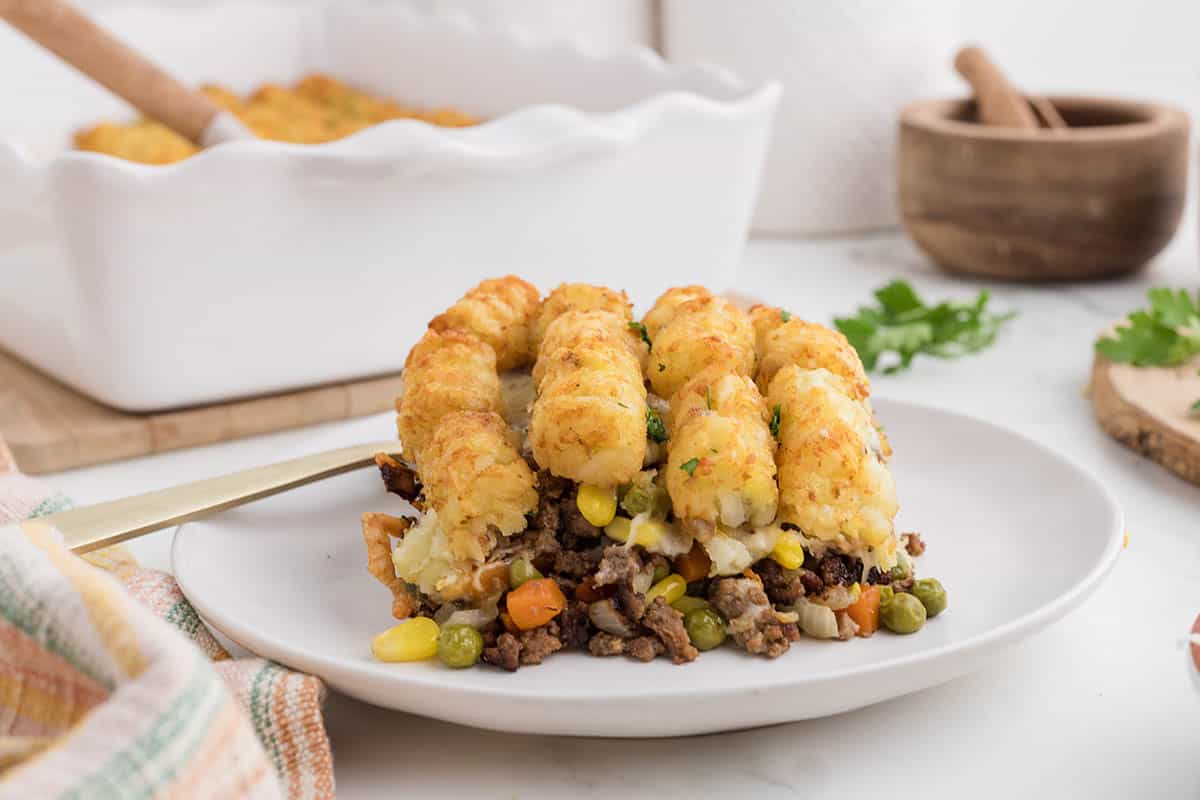 A serving of ground beef tater tot bake a plate with a fork.