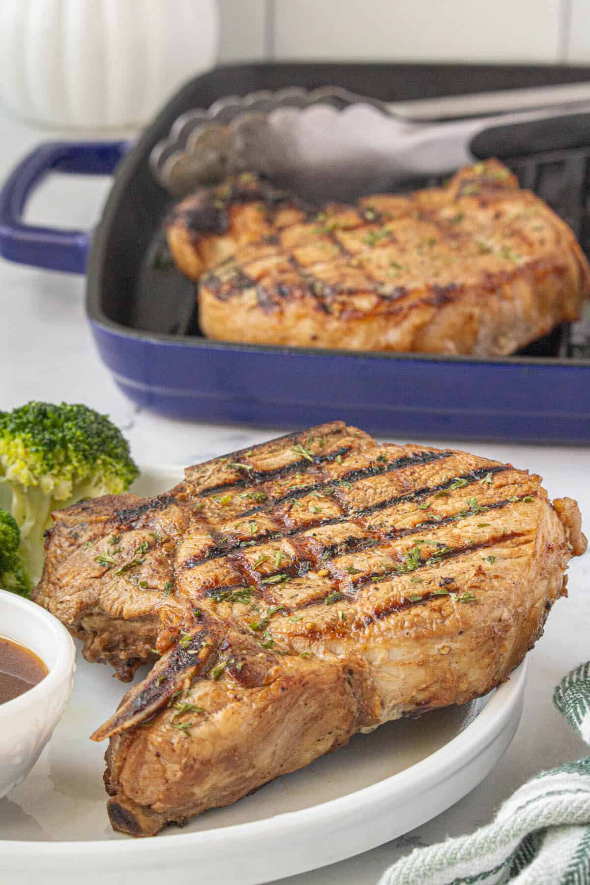 Texas Roadhouse grilled chops on a plate. Served with dipping sauce and fresh broccoli.