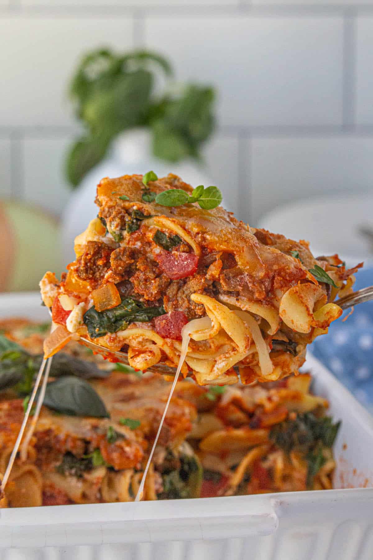 Eight layer casserole in a baking dish. A spatula is scooping out a serving.