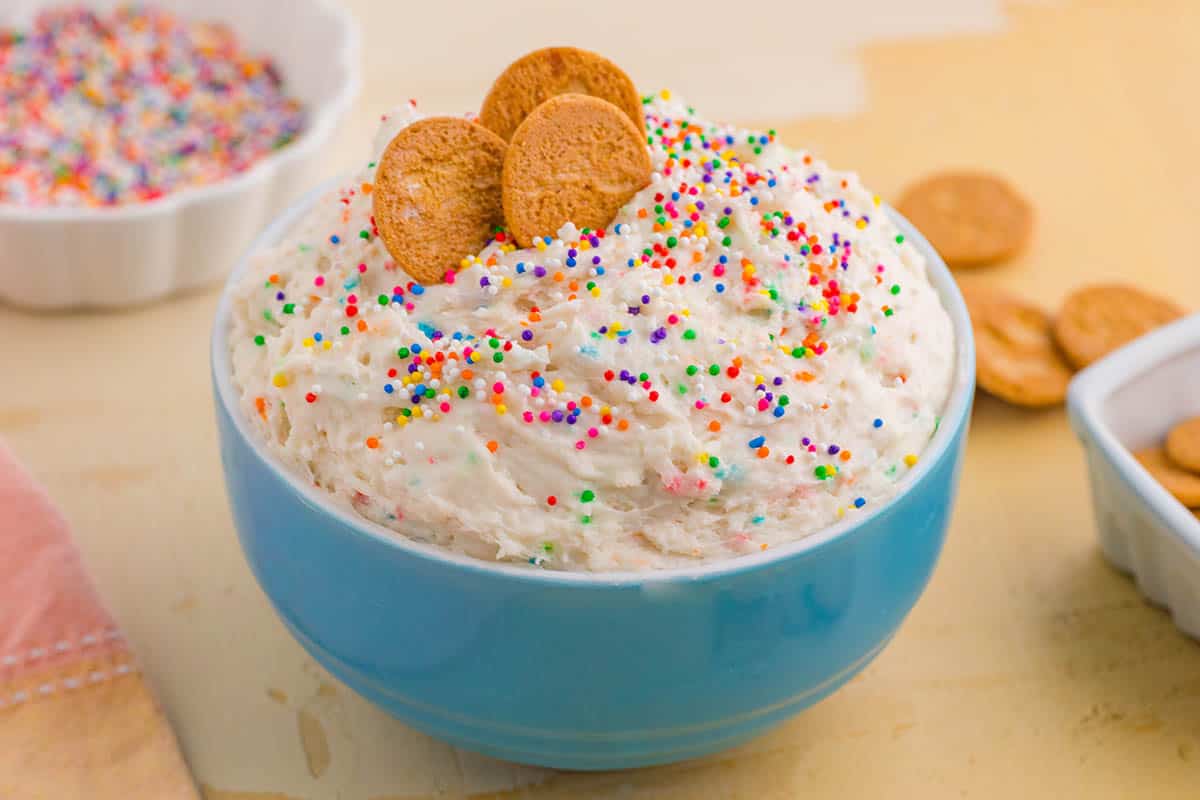 Funfetti Dunkaroo Dip in a bowl with cookies on the side for dipping.