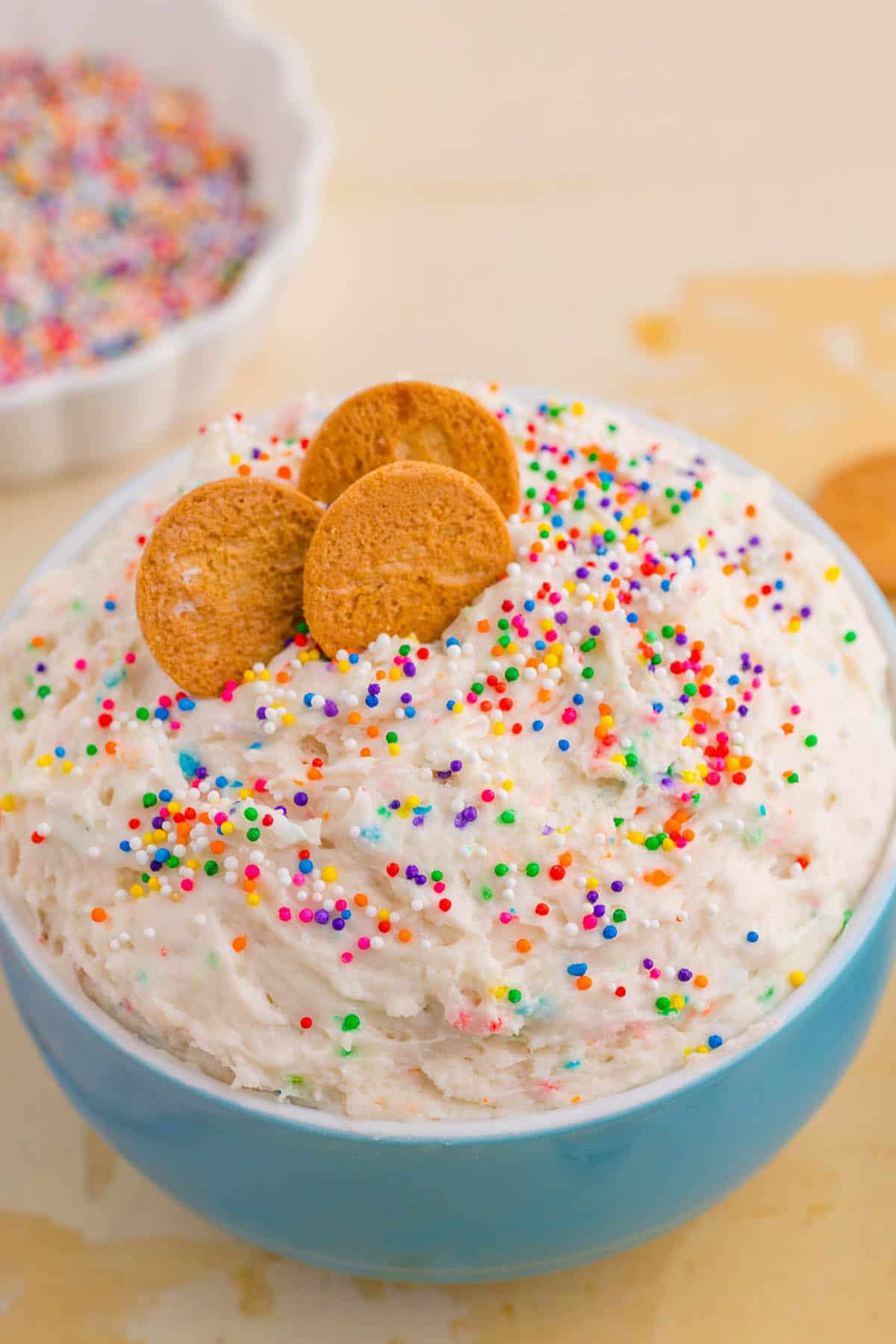 Cake mix funfetti dip in a bowl with cookies for dipping.