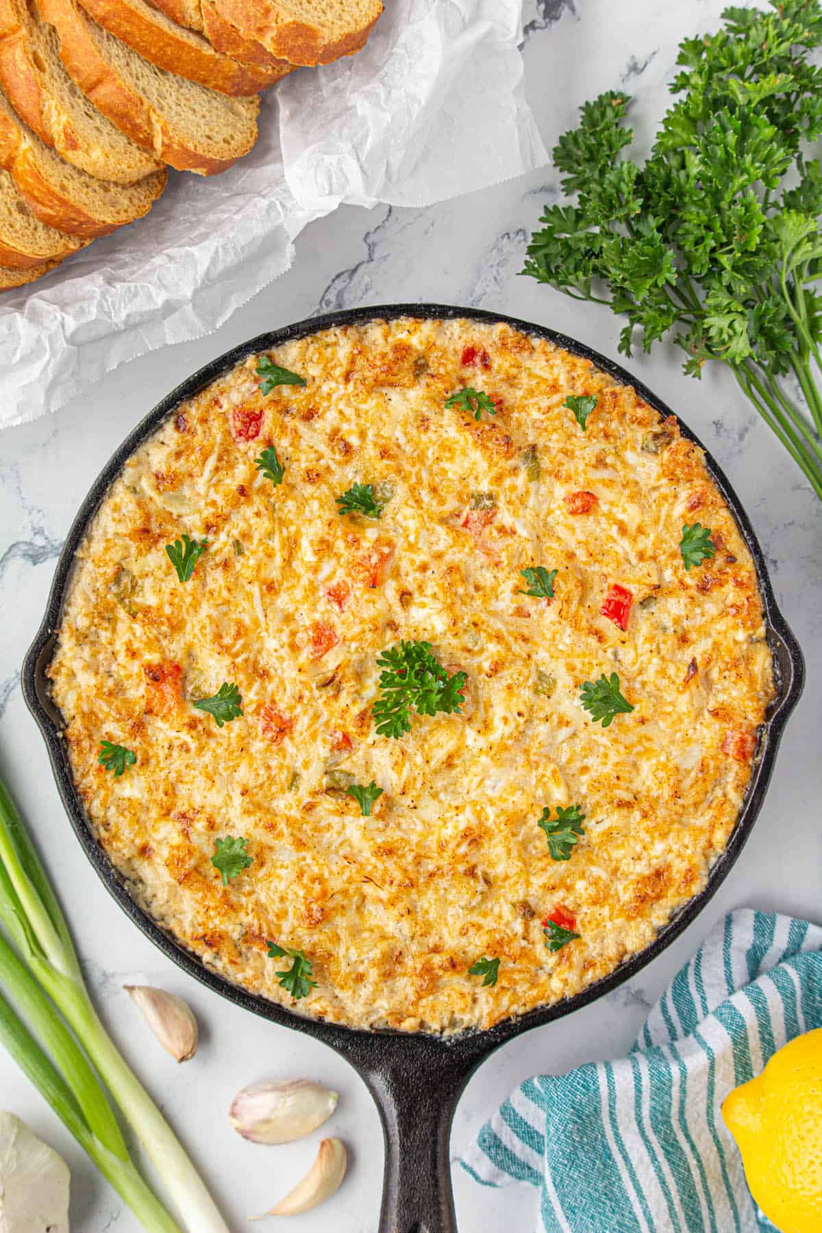 Hot crab dip baked hot and bubbly in a cast iron skillet.