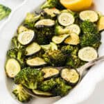 Roasted Zucchini and Broccoli on a platter with a serving spoon.