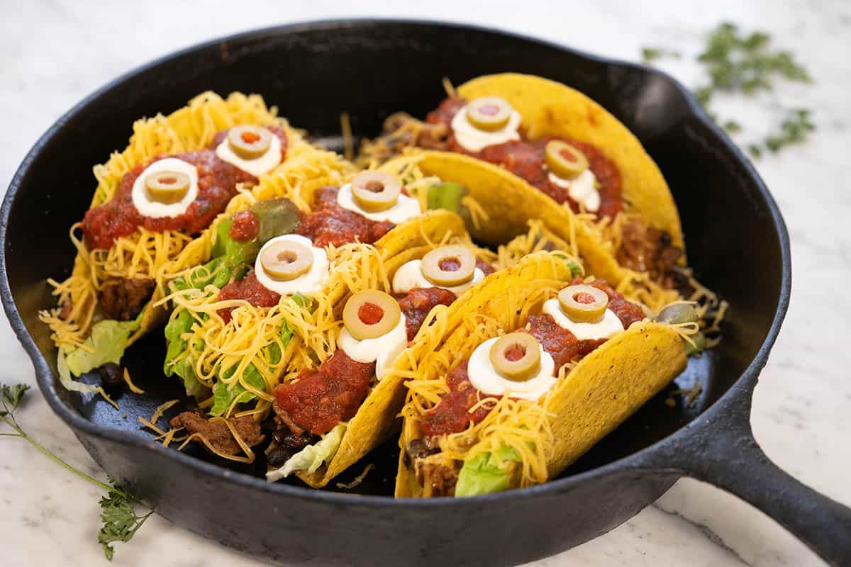 Scary tacos decorated for Halloween in a skillet.