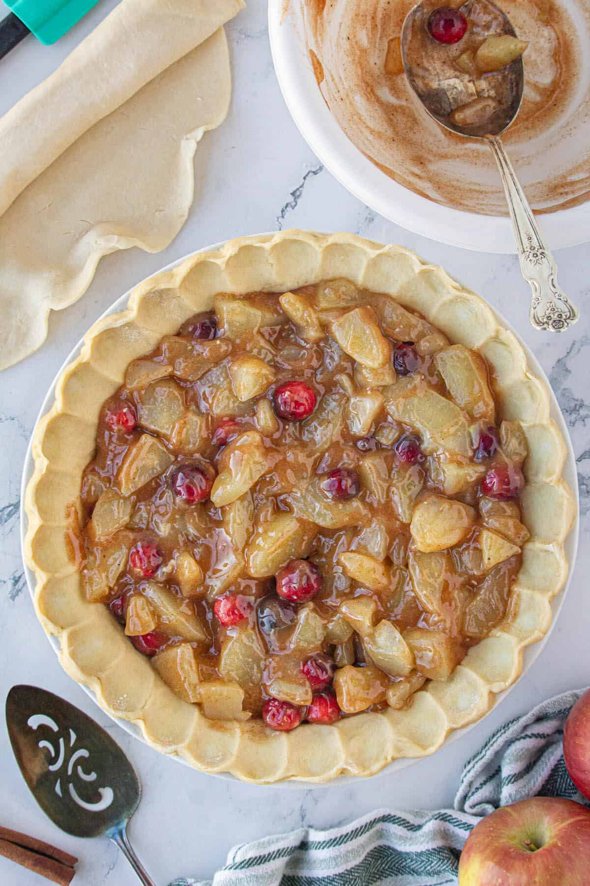 Pie filling spooned into a pie crust, ready to bake.