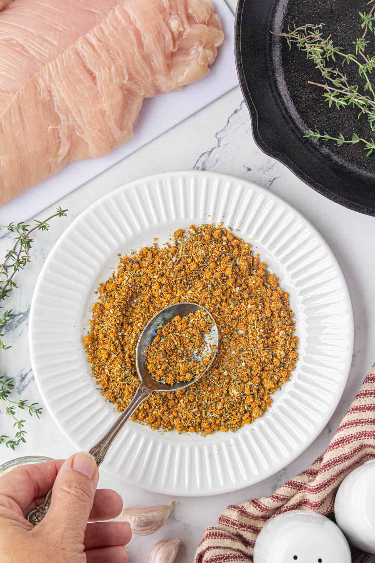 Poultry spices being mixed together on a plate.