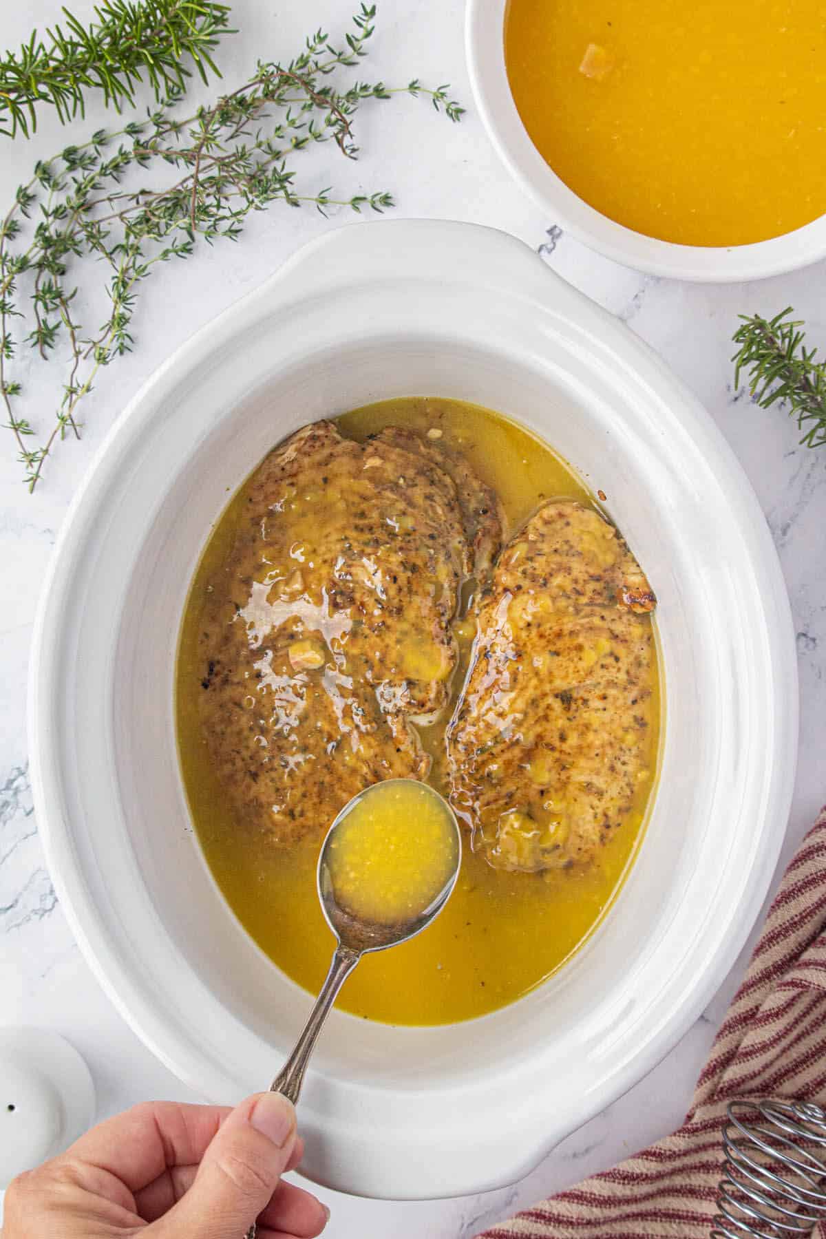 Gravy spooned over turkey tenderloins before cooking in the slow cooker.