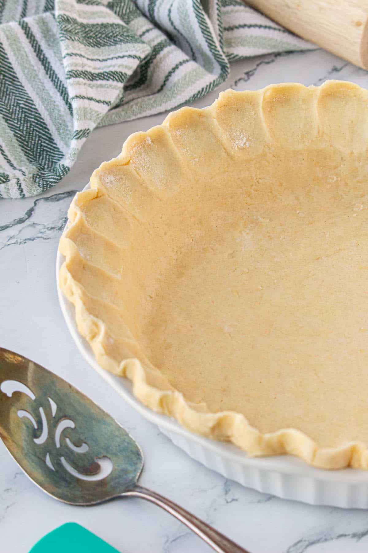 An unbaked pie crust in a deep dish pie tin.